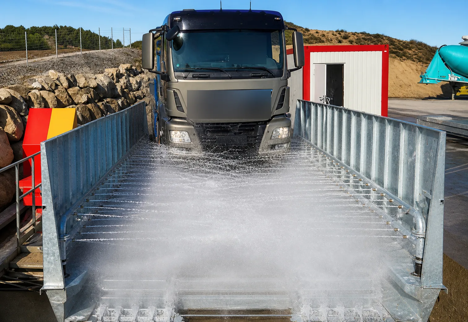 Vrachtwagen rijdt door een stalen wielwasbak waarin sproeiers de onderkant en de banden afspuiten