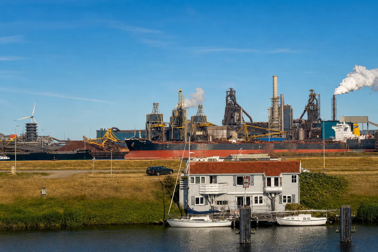Zwaar staal- en metaalcomplex aan het water met hoogovens