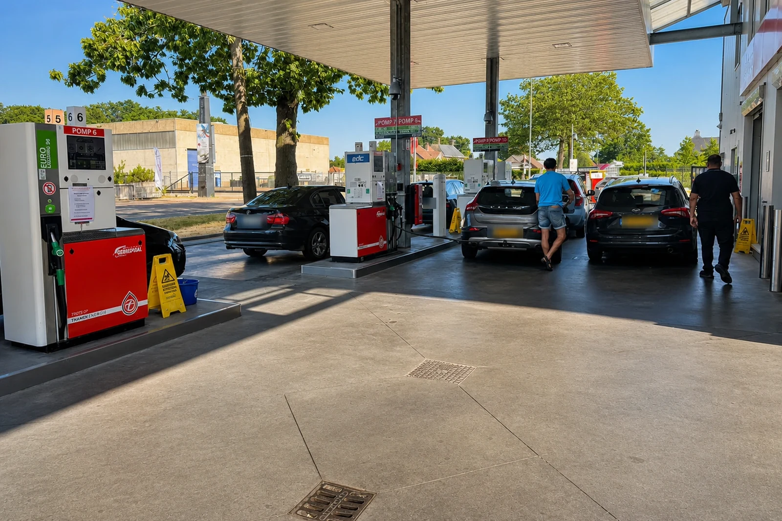 Overkapt tankstation met afleverzuilen en tankende auto’s